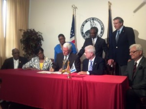 Ceremonial signing (L-R seated) State Rep. Charlie Brown, State Senator Earline Rogers, Governor Pence, State Senator Ed Charbonneau, State Rep. Ed Soliday (Standing L-R) Mayor Karen Freeman-Wilson, Sen. Lonnie Randolph, and State Rep. Hal Slager